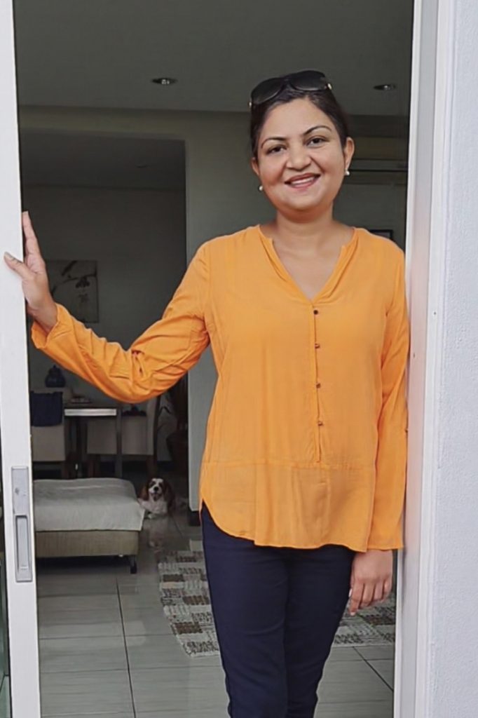 Parveen, standing at the entrance of her living room.