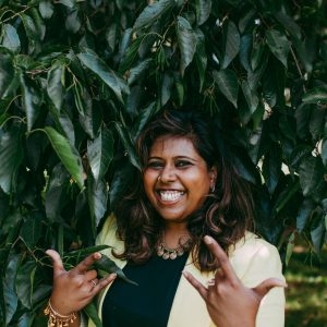 Nisha smiling in the garden with a 'you got this attitude'.